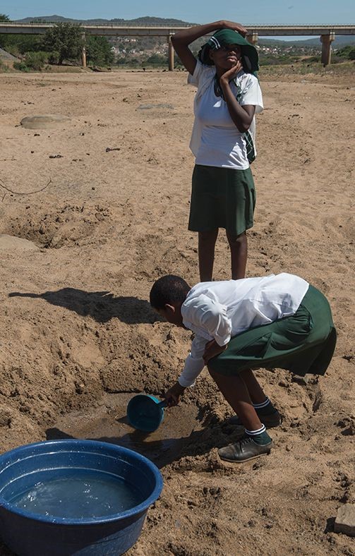 Một bé gái đang cố lấy nước từ một vũng nông tại Nongoma, phía tây bắc Durban trong đợt hạn hán ở Nam Phi - Ảnh: AFP