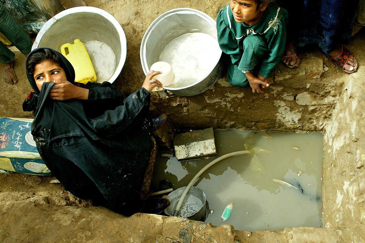 Một thiếu nữ lấy nước từ một cái hố ở Tariq, một quận của Saddam, thành phố bên cạnh Baghdad - Ảnh: Reuters