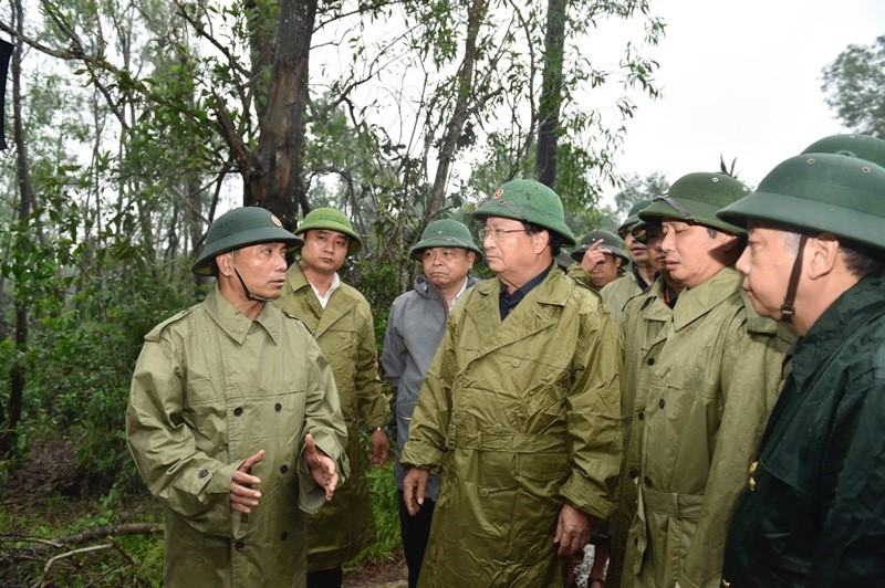 Tư lệnh Quân khu 4 Nguyễn Doãn Anh (bìa trái) báo cáo tình hình với Phó Thủ tướng Trịnh Đình Dũng (giữa) tại huyện Phong Điền, Thừa Thiên Huế, chiều 13/10. Ảnh: VGP/Nhật Bắc