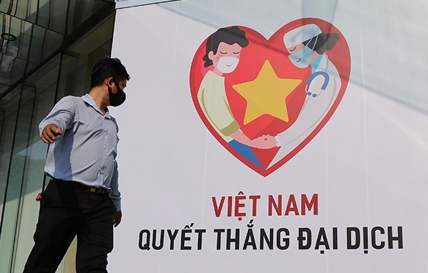Khẩu hiệu “Việt Nam quyết thắng đại dịch” đặt trước một trung tâm thương mại ở Quận 1, TPHCM. Ảnh: PLO